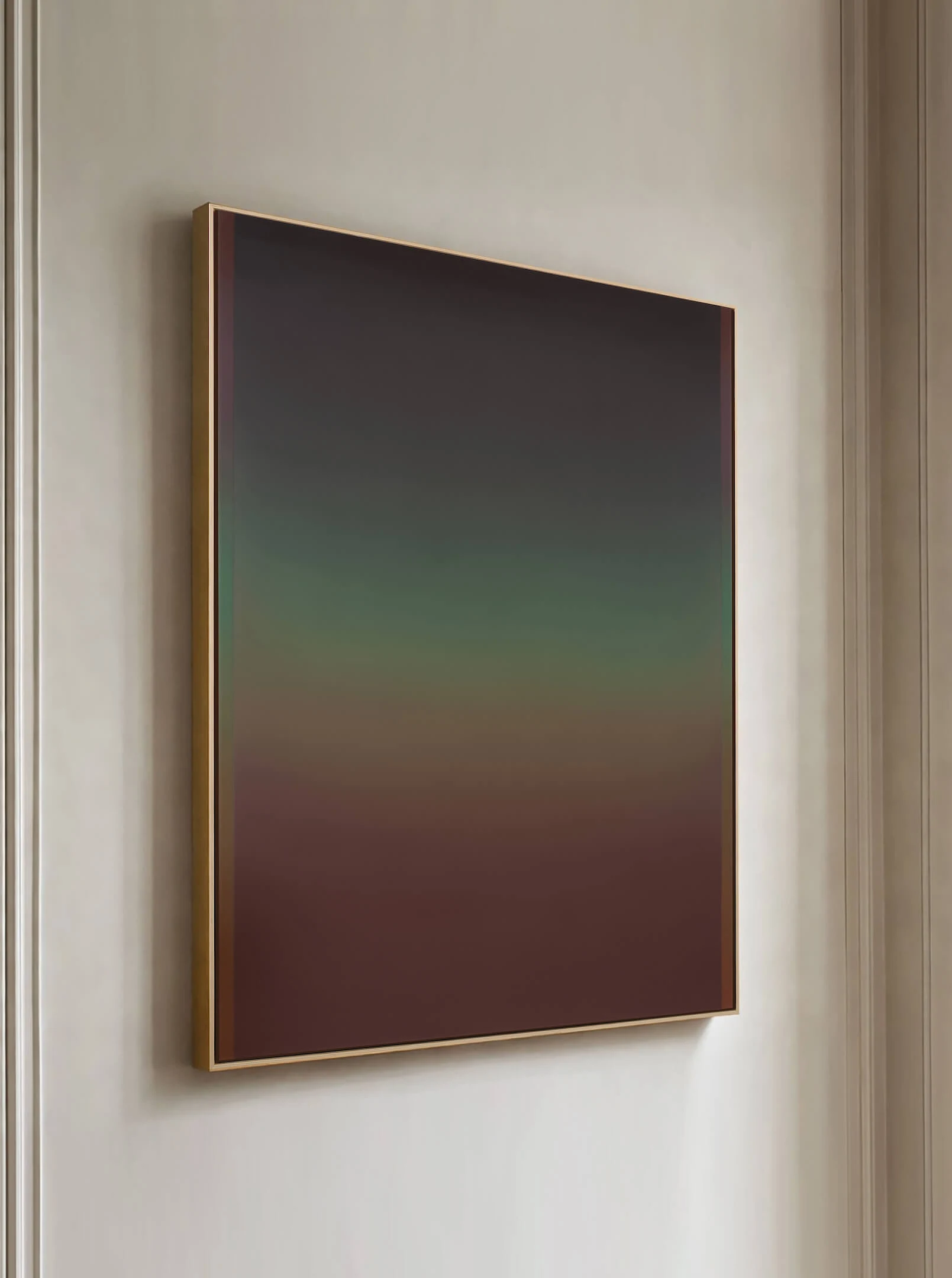 A framed painting seen at an angle against a pale wall, muted green above giving way to a deep russet lower half.